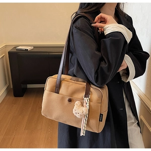 Detail view of khaki canvas tote bag featuring a decorative brown button and a cute plush bear