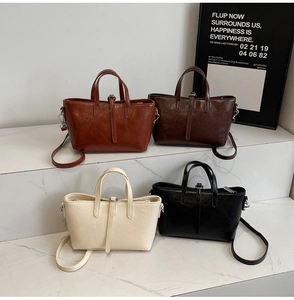 Collection of retro bucket bags in brown, coffee, beige, and black on marble stands