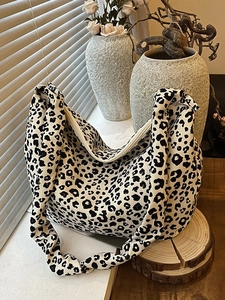 Chic black and white leopard print tote bag with soft canvas texture and zipper closure