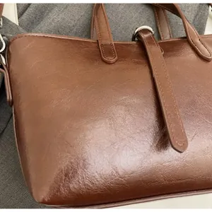 Close-up of soft brown vintage leather bag texture with metallic buckle detail