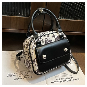 Detail of vintage floral print handbag with leather flap pocket on art magazine background