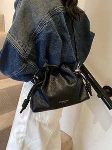 Fashionable black pleated cloud bucket bag with gold lettering and adjustable shoulder strap