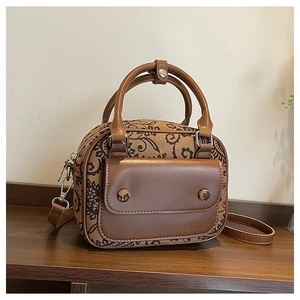 Detail view of vintage brown floral tapestry fabric and leather handles on the small bag