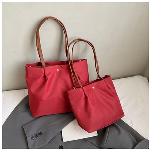 Detailed view of red nylon tote bag set with brown straps and spacious interior