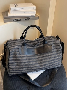 Blue and black striped sports travel bag with shoe compartment on a cozy white background