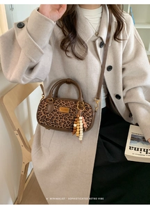Détail du sac à main rétro imprimé léopard avec bordure en cuir brun et pompon perlé