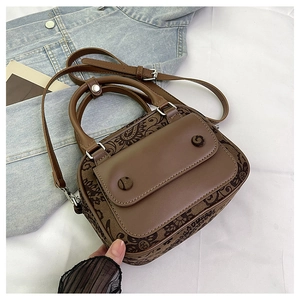 Detailed view of a vintage brown handbag with floral prints and leather stitching