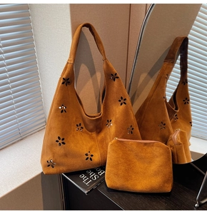 Détail du sac cabas en daim marron avec fleurs découpées et pochette assortie