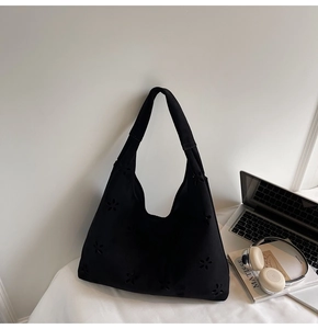 Détail du motif floral découpé au laser sur le sac hobo minimaliste noir