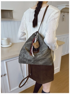 Détail du sac cabas en cuir mat vert olive avec logo M et charm ours en peluche