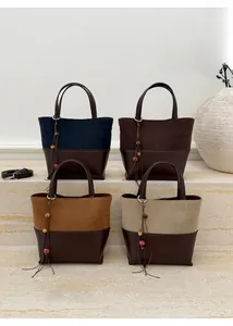 Detailed view of colorful suede bucket bags with leather trim and tassel accents