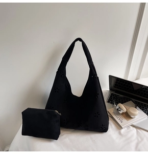 Détail de motifs floraux découpés au laser sur un sac hobo en daim avec pochette assortie