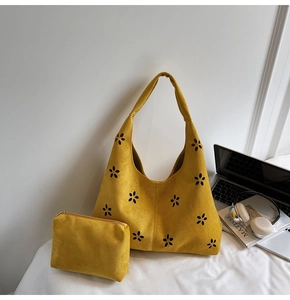 Détail du sac hobo jaune ajouré et de sa pochette assortie dans un décor lifestyle