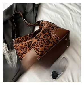 Macro shot of leopard print tote bag with brown faux leather base and protective metal feet