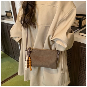 Bolso bandolera de cuero esmerilado marrón con detalle de borla de cuentas de madera
