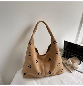 Vue détaillée du sac hobo marron avec des motifs floraux ajourés coupés au laser