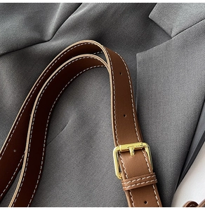 Close-up of leopard tote brown leather strap with gold buckle and white contrast stitching