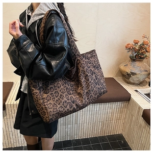 Detailed view of the large leopard print tote bag styled with a black leather jacket