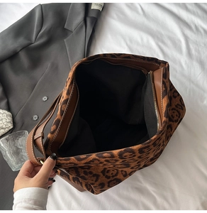 Detail shot of leopard print tote bag interior with metal zipper and leather trim