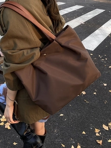 Minimalist large brown tote bag with leather straps on model in autumn street setting