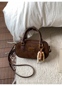 Détail du sac Boston vintage marron foncé avec empiècements en daim et logo doré