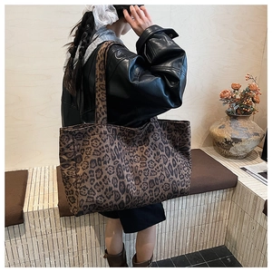 Detail shot of large leopard print tote bag with thick shoulder strap on female model