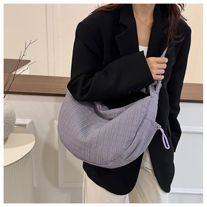 Detail of light purple quilted crescent bag with square stitching and long zipper puller