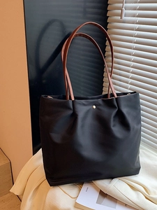 Chic black nylon tote bag with brown leather handles and gold snap button closure