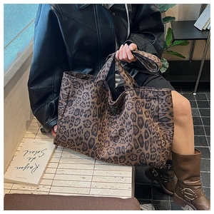 Detailed view of the large leopard print tote bag styled in a cafe setting