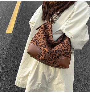 Detail view of the leopard print tote bag featuring brown leather corners and white stitching