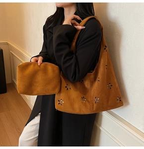 Vue détaillée du sac cabas en daim marron foncé avec motifs floraux ajourés au laser