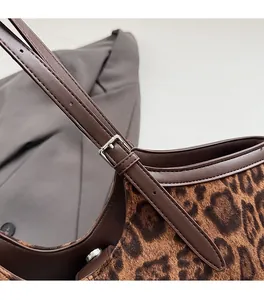 Close-up of leopard print suede texture with brown leather strap and silver metal buckle
