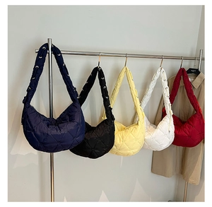 Row of quilted crossbody bags in five colors with metal eyelet straps and moon shape