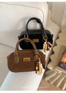 Détail de sacs Boston rétro en daim avec breloques en perles de bois et plaques d'or
