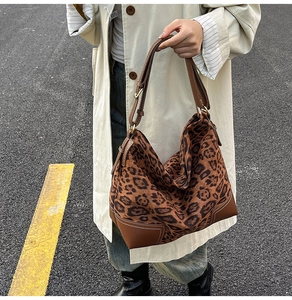 Close-up of leopard print tote bag with brown leather accents and contrast stitching