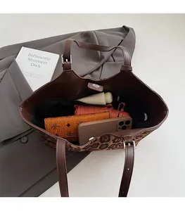 Interior capacity of leopard print tote bag holding phone, wallet, and umbrella
