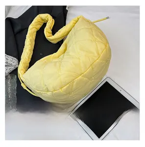 Detailed view of yellow quilted heart-pattern handbag with soft puffer fabric texture