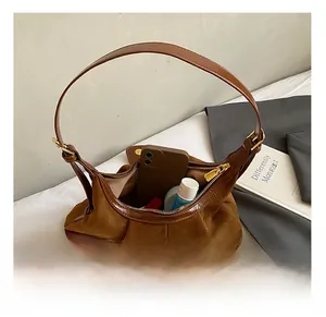 Vue intérieure du sac cabas en daim marron foncé montrant le rangement des cosmétiques