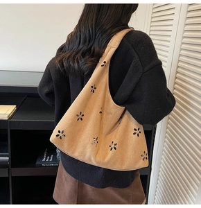 Détail du motif floral découpé au laser sur un sac cabas en daim de couleur camel