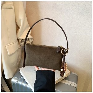 Bolso de hombro en ante verde oliva con asa de cuero marrón y colgante de cuentas