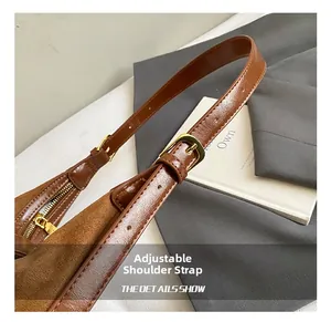 Détail de la bandoulière en cuir réglable avec boucle dorée sur un sac marron chic