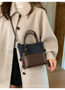 Detail of color-block crossbody bag with wooden bead charm on beige wool coat