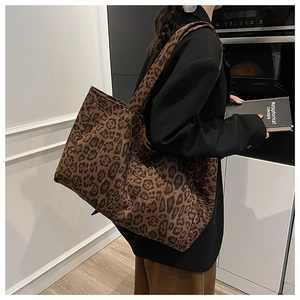 Detailed view of leopard print tote bag being worn to show large capacity and texture