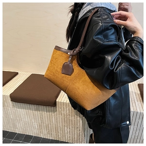 Close-up of vintage brown suede tote bag with leather straps and minimalist hanging detail