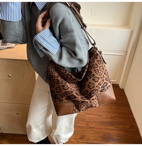 Close-up of leopard print tote bag with brown leather reinforced corners and stitching
