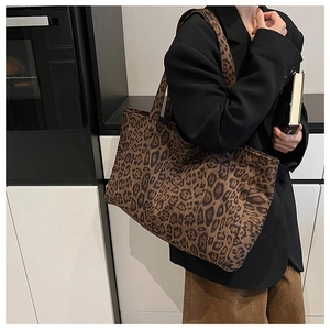Detailed shot of large leopard print tote bag worn with a professional black blazer