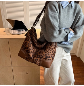 Detail shot of leopard print tote bag featuring leather base corners and large capacity