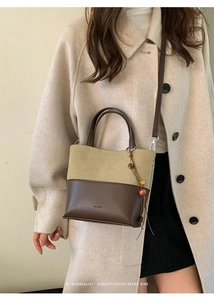 Detail of vintage crossbody bucket bag featuring suede contrast and bead ornament