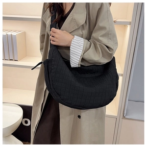 Close-up of a black quilted nylon crescent crossbody bag with thick shoulder strap