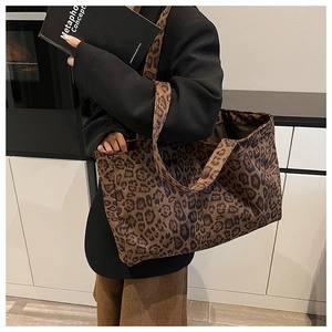 Detailed close-up showing the leopard print pattern and sturdy canvas texture of the tote bag